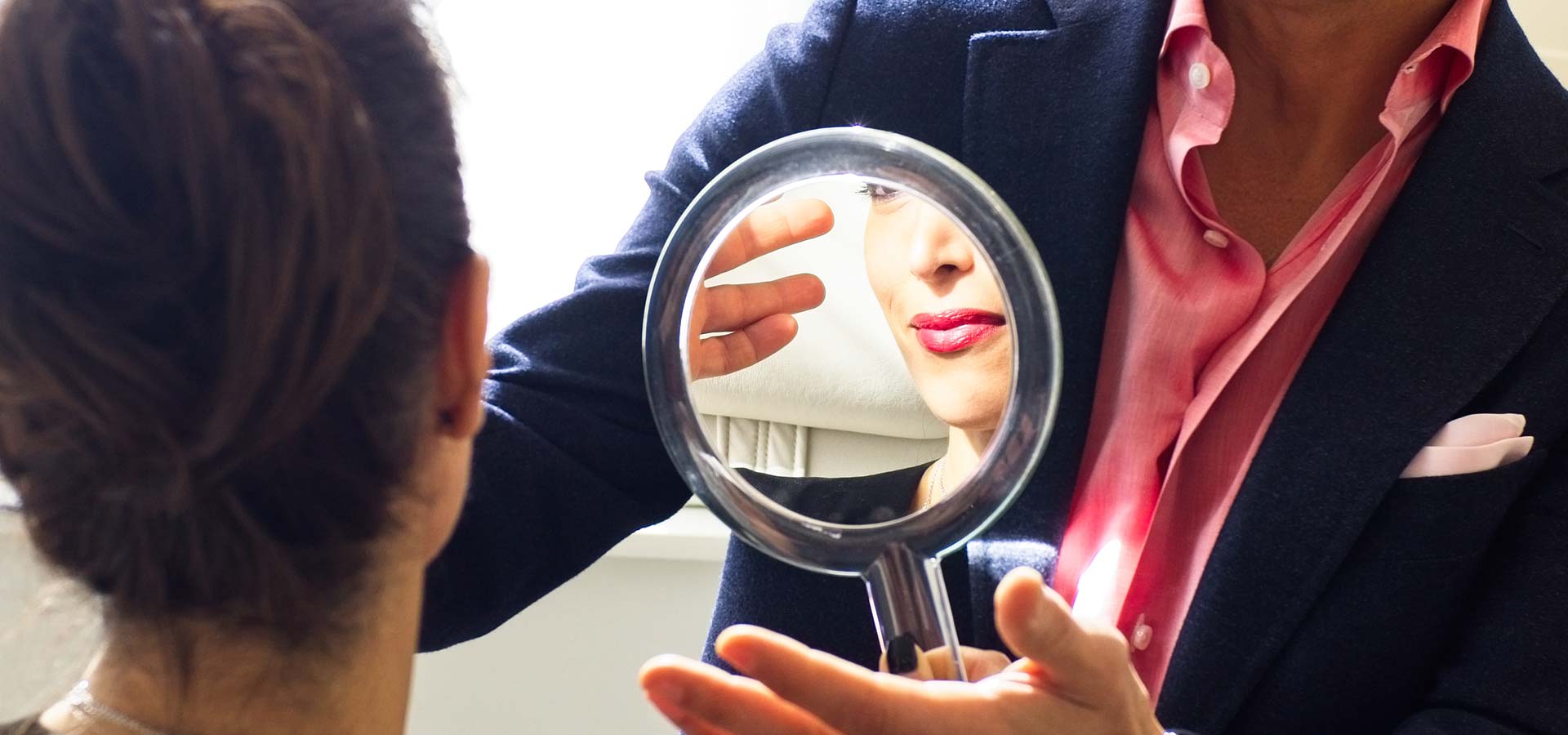 Beautiful woman looking in the mirror at herself.