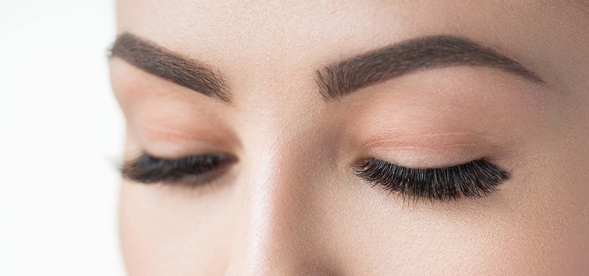 Close-up of closed woman's eyes and eyebrows.