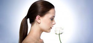 Woman smelling a white flower.