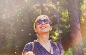 A woman walking in a park on a sunny day.